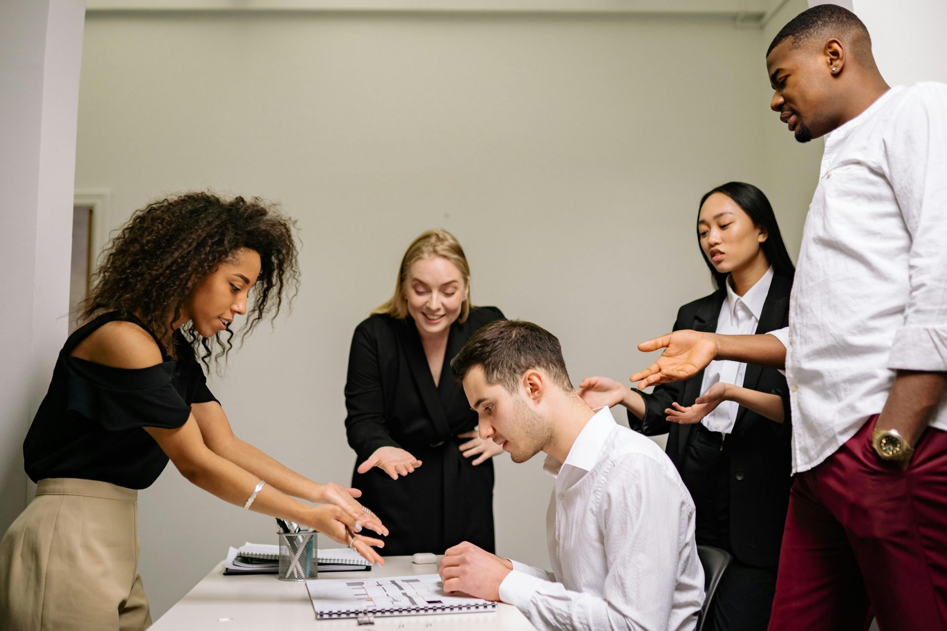 A diverse group of professionals engaged in a collaborative discussion in an office setting.